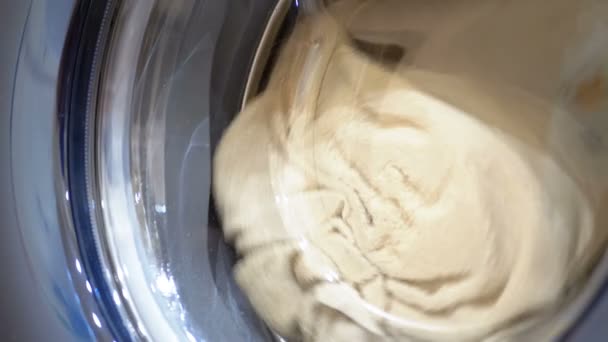 Барабан стиральной машины вращается с одеждой — стоковое видео