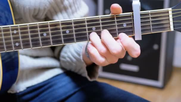 Adam müzisyen bir Capo ile akustik gitar çalar — Stok video