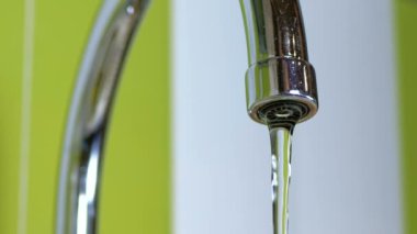 Bir lavabo içine musluk çalışan su. Ağır çekimde 180 fps. Yakın çekim. Boru banyoya dışarı akan su jetleri makro çekim. Bir musluk su akımları.