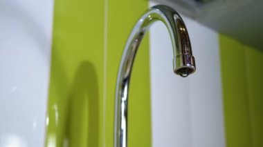 Water Dripping from the Tap into a Sink. Slow Motion