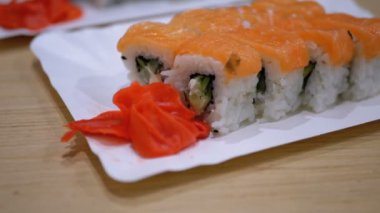 Bir Japon restoranında beyaz tabakta somon suşi rulo