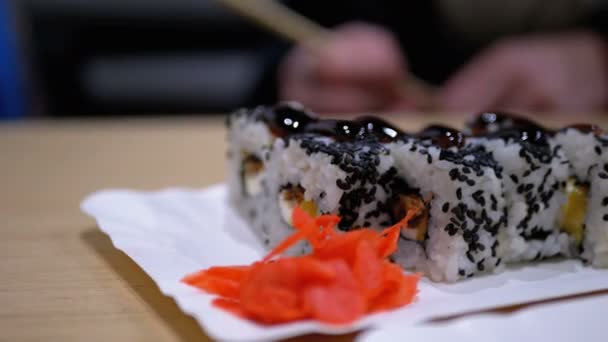 Sushi rullar med lax på en vit platta i en japansk restaurang — Stockvideo