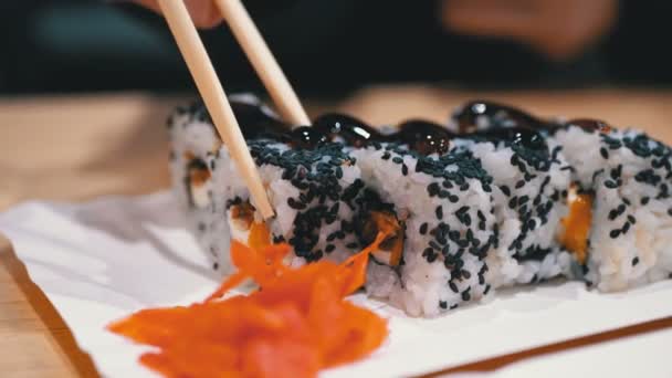 Hand mit Essstäbchen beim Sushi-Essen in einem japanischen Restaurant — Stockvideo