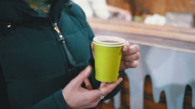 Sokakta kışın ayakta iken bir plastik kap kadın içecekler Mulled şarap