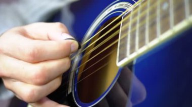Adam bir arabulucu ile bir akustik gitar çalmak. Ağır çekim