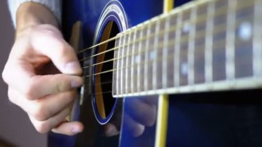 Adam bir arabulucu ile bir akustik gitar çalmak