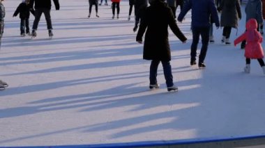 Güneşli bir günde buz pateni pisti üzerinde patinaj insanlardır. Ağır çekim