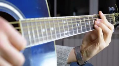 Adam akustik gitar çalıyor.