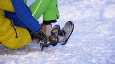 Bir karlı tepeden aşağı kızakla çocuk. Ağır çekim