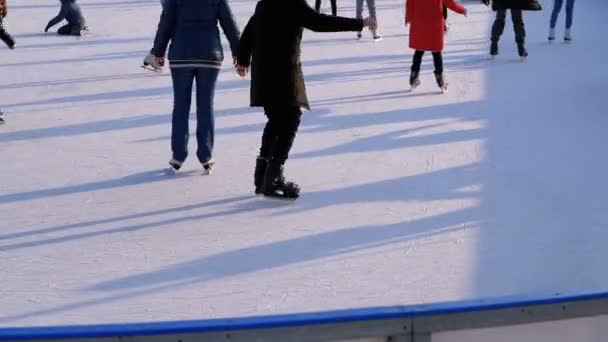 La gente patina en pista de hielo en el día soleado — Vídeo de stock