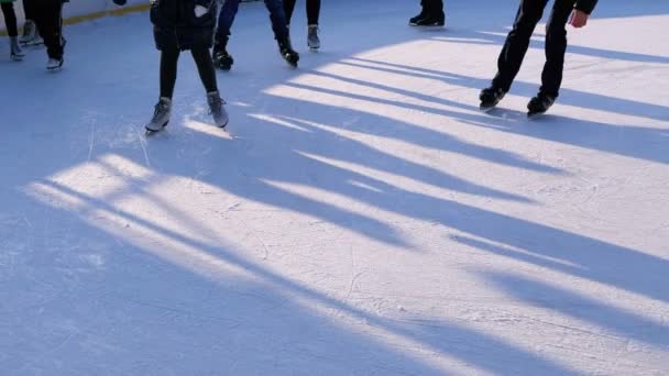 La gente está patinando en la pista de hielo en el día soleado. Moción lenta — Vídeo de stock