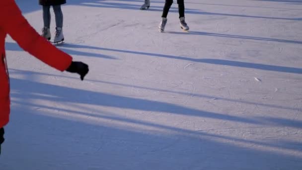 La gente patina en pista de hielo en el día soleado — Vídeo de stock