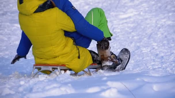 Kinderen rodelen een besneeuwde heuvel af. Slow Motion — Stockvideo