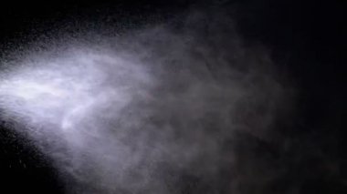 Su sprey siyah bir arka plana dayanır. Ağır çekim