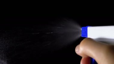 Su sprey siyah bir arka plana dayanır. Ağır çekim