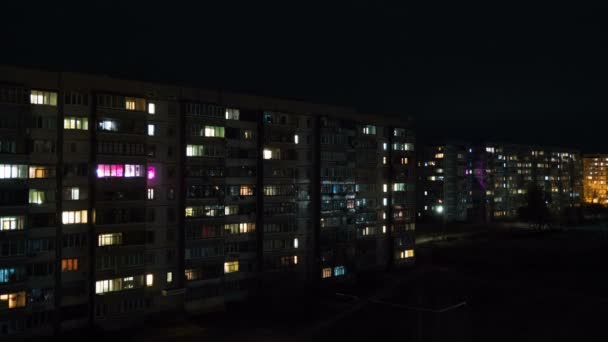 Edificio de varios pisos con iluminación cambiante de ventanas por la noche — Vídeo de stock