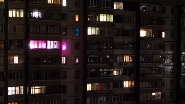 Edificio de varios pisos con iluminación cambiante de ventanas por la noche — Vídeo de stock