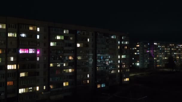 Edificio de varios pisos con iluminación cambiante de ventanas por la noche — Vídeos de Stock