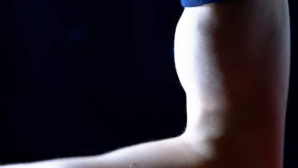 在黑色背景上的一个年轻的曼斯手抽水二头肌 — 图库视频影像