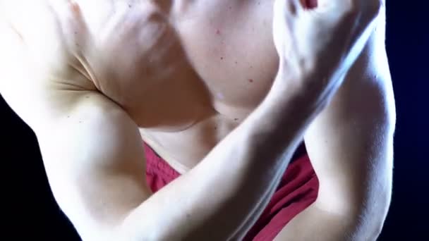 Sexig kropp av en muskulös manliga idrottare i röda Shorts böjning armmuskler på en svart bakgrund — Stockvideo