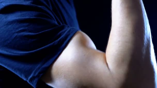 Napompowanie Biceps na rękę Mans Młodzi na czarnym tle i w czarny T-shirt — Wideo stockowe