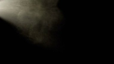 Su sprey siyah bir arka plana dayanır. Ağır çekim