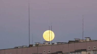 Büyük dolunay Multistory binanın çatı üzerinde hareket ediyor