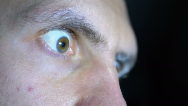 Utseendet på rädsla, utstående ögon av en ung Man på en svart bakgrund — Stockvideo