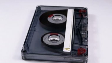 Vintage şeffaf ses kaset beyaz arka plan üzerinde döner. Retro teyp kaseti ile boş bir etiket. Eski müzik. Yakın çekim.