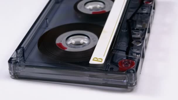 Cassete de áudio transparente vintage gira em fundo branco — Vídeo de Stock