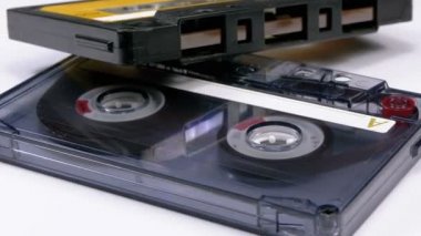 İki Vintage ses kaset beyaz arka plan üzerinde döner. Boş bir etiket ile şeffaf ve sarı Retro teyp kaseti. Eski müzik. Yakın çekim.