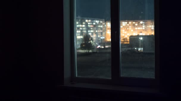 Blick aus dem Fenster bei den Lichtern der Fenster in Hochhäusern in der Nacht — Stockvideo