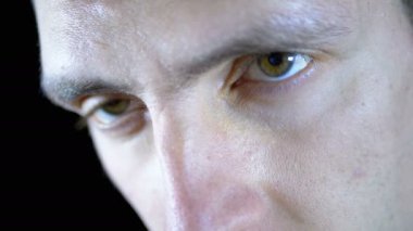 Ciddi bir genç görünümünü bir siyah arka plan üzerinde konsantre çalışır adam. Ağır çekim