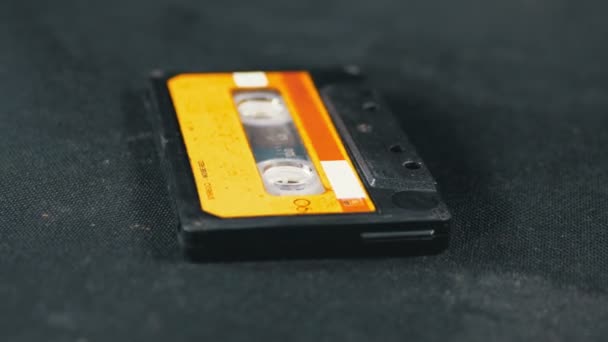 Cassette audio jaune vintage tourne sur fond noir — Video