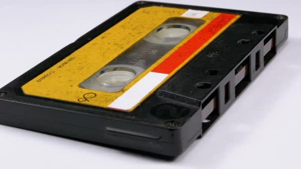 Vintage žluté Audio kazeta se otočí na bílém pozadí — Stock video