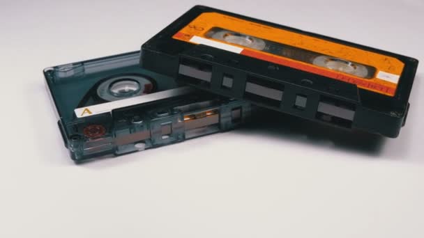 Дві старовинні аудіокасети обертаються на білому тлі — стокове відео