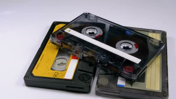 Три старовинні аудіокасети обертаються на білому тлі — стокове відео