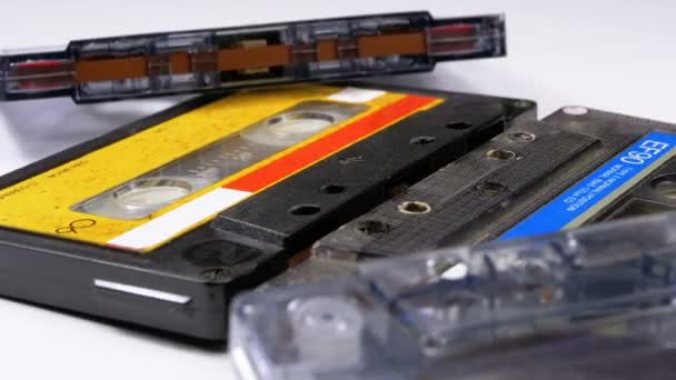 Четыре аудиокассеты вращаются на белом фоне — стоковое видео