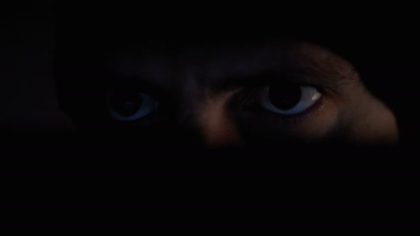 Чоловічий хакер в капелюсі, працює над монітором ноутбука на ніч — стокове відео