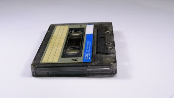 Vintage cassette de audio gira sobre fondo blanco — Vídeos de Stock
