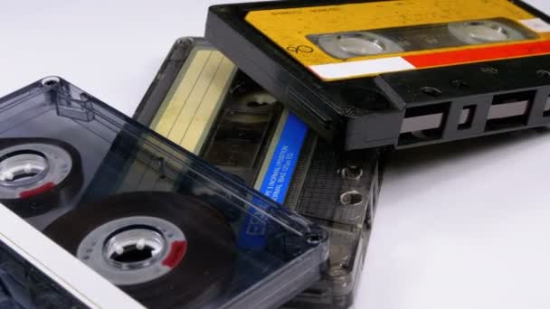 Beyaz arka plan üzerinde üç Vintage ses kasetleri döndürmek — Stok video
