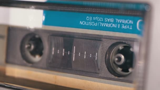 El cassette de audio se inserta en la cubierta de la grabadora de cinta de audio que se reproduce y gira — Vídeos de Stock