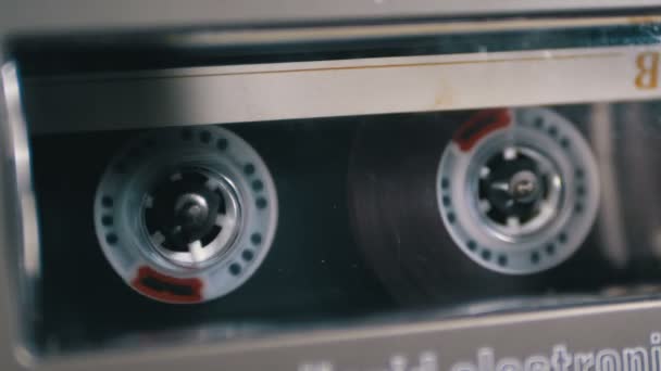 Аудиокассеты вставляется в палубу аудиомагнитофона воспроизведения и вращения — стоковое видео