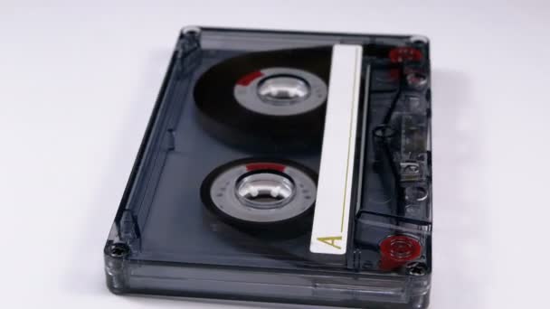흰색 바탕에 회전 하는 투명 한 오디오 카세트 — 비디오