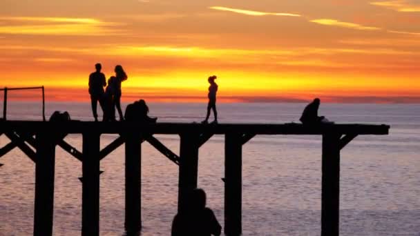 夕暮れ海桟橋の若い人々 のシルエット — ストック動画