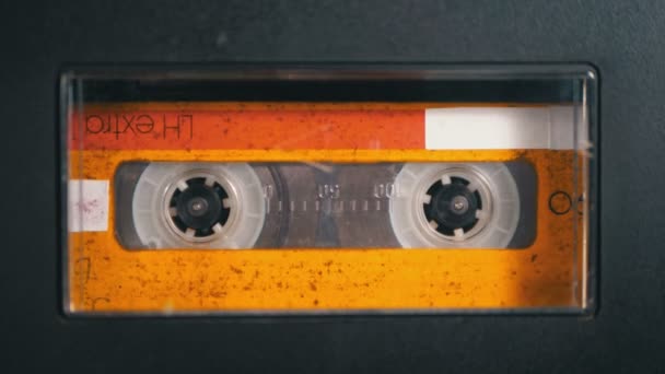 El cassette de audio se inserta en la cubierta de la grabadora de cinta de audio que se reproduce y gira — Vídeo de stock