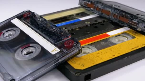 Quatro cassetes de áudio giram em fundo branco — Vídeo de Stock