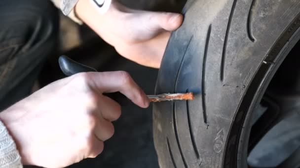 Reparera punktering däck utan motorcykel med en sele, gör det själv. — Stockvideo