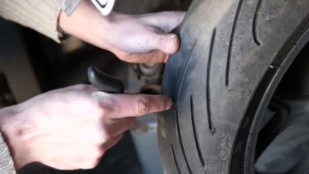 Reparatie doorprikken tubeless banden motorfiets met een harnas, doe het zelf. — Stockvideo