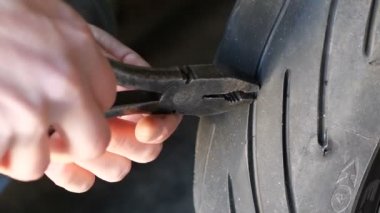 Çivi kullanarak pense motosiklet tekerlek lastiği dışarı çekin